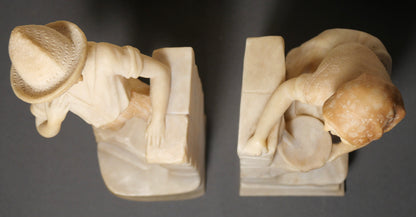 Pair of Circa 1925 Italian Art Deco Enrico Brunelleschi Carved Two-Tone Alabaster Figural Young Boy and Girl by Stone Wall Bookends